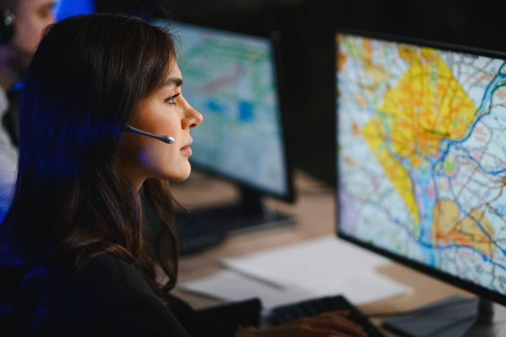 Dispatcher with headset monitoring a live trip map