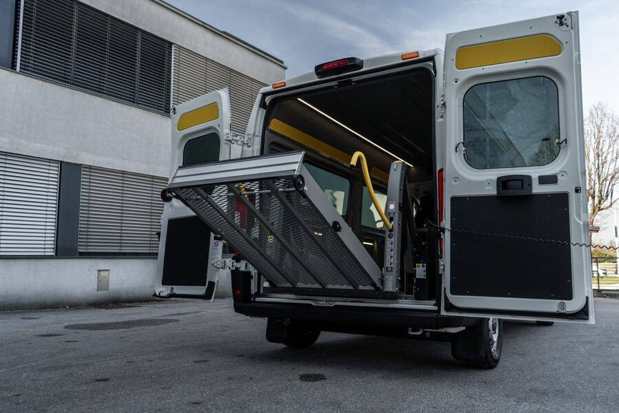 White wheelchair-accessible van with ramp deployed