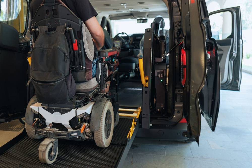 Rider using a wheelchair lift to enter an accessible van
